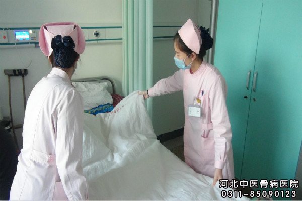 中医骨科护士在为患者铺床