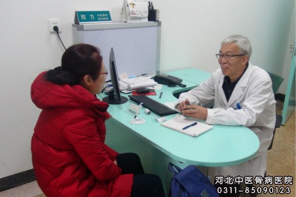 我院中医骨科权力主任在门诊与患者交流